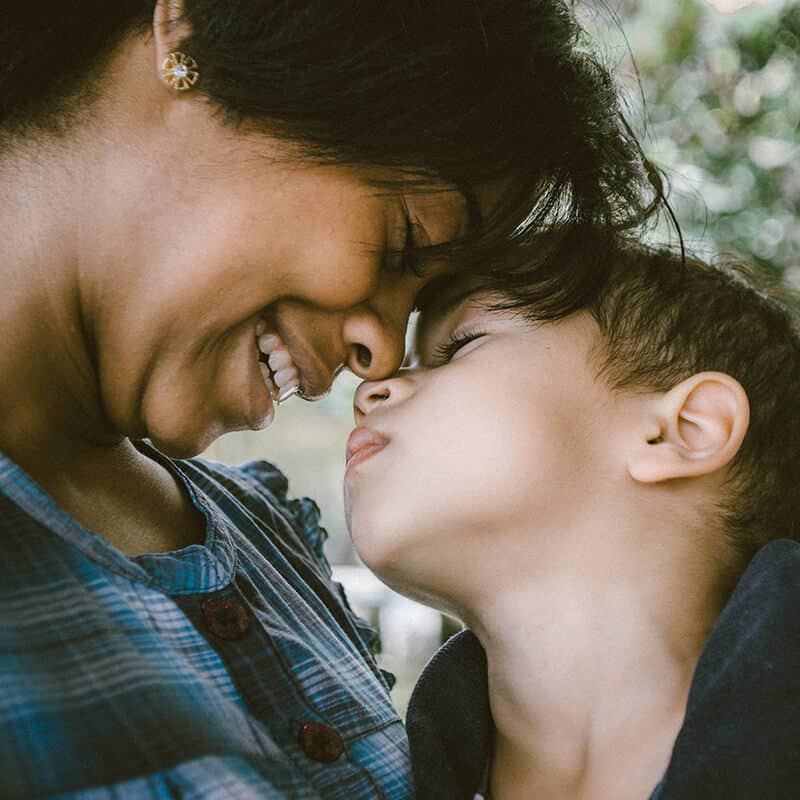A mother and her child are smiling and embracing each other with their noses touching. As depicted in YTherapy, this woman invested in her mental health and now has a stronger connection with her child and family after seeking counselling in Central London.